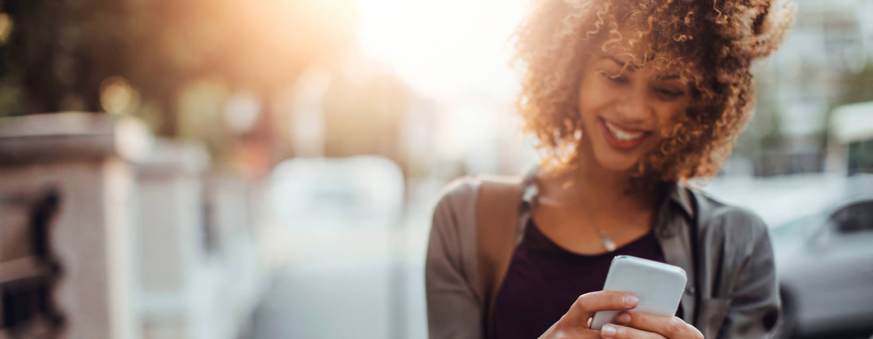 a person smiling while looking at a phone