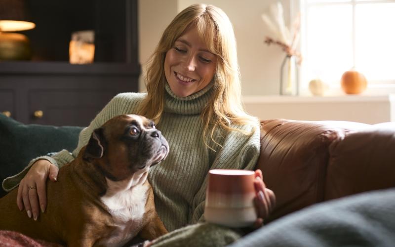 a woman sitting on a couch with a dog